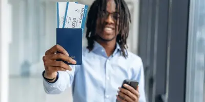 Traveller holding airline tickets at an airport departure hall