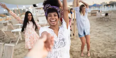 Group celebrating at a beach event at sunset