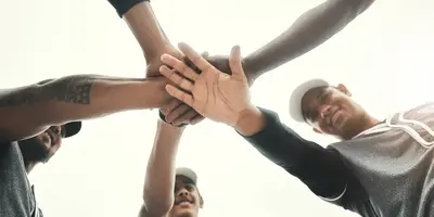 Team members stacking hands together in a show of unity